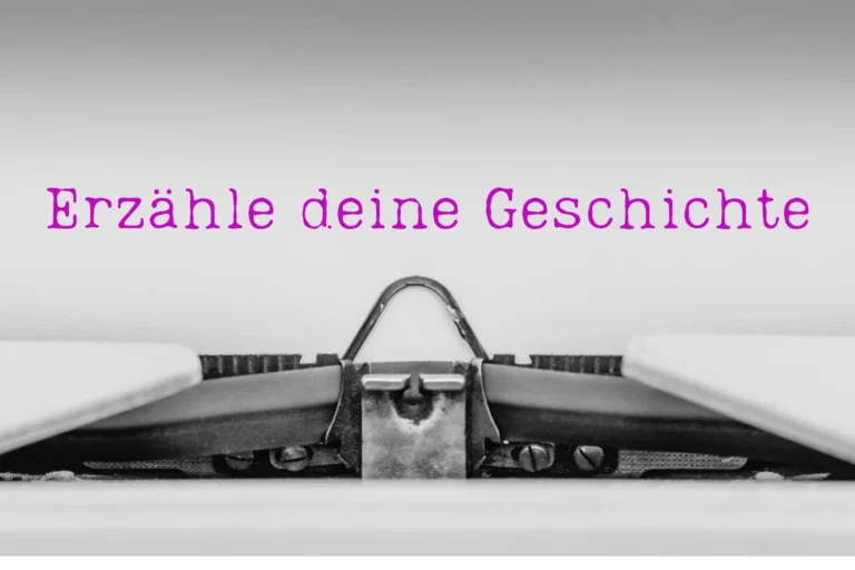Das Bild zeigt einen Ausschnitt einer mechanischen Schreibmaschine, in der ein Blatt eingezogen ist, auf dem steht: Erzähle deine Geschichte.